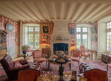 Salon Rose: pink toile walls, beamed ceiling, fireplace, portraits and armchairs around a low table